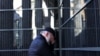 A man reacts in front of a wall bearing the names of victims during a ceremony marking International Holocaust Remembrance Day at the Holocaust Memorial Center in Budapest, Hungary, Jan, 26, 2024. 