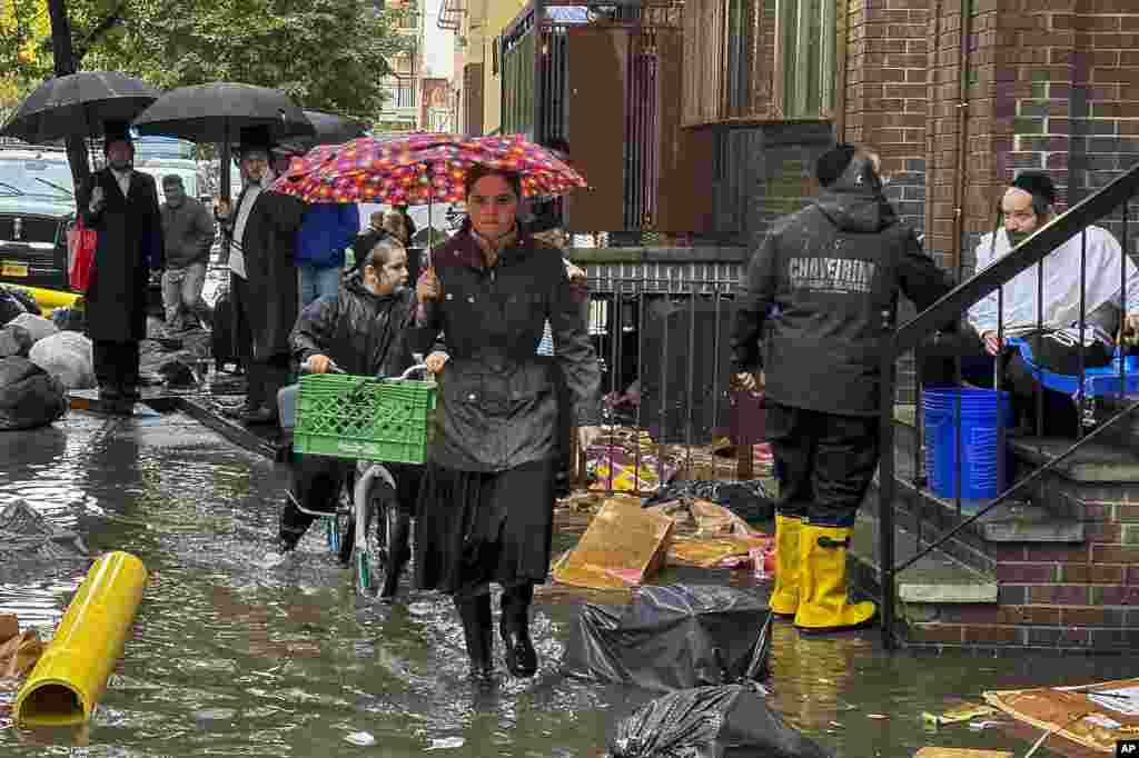 Peatones caminan por una acera inundada, el 29 de septiembre de 2023, en el distrito de Brooklyn en Nueva York, EEUU.&nbsp;