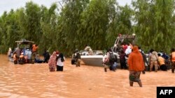 This photograph taken Aug. 20, 2024 shows police boats being used to carry people following heavy rains that damaged National Road 25 from the Nigerien capital Niamey to the provinces of Tillabéri and Tahoua in western Niger. 