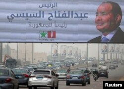 Vehicles drive past a banner and posters of presidential candidate and current Egyptian President Abdel Fattah al-Sisi ahead of the presidential elections to be held inside the country next week, in Cairo, Egypt, Dec. 5, 2023.