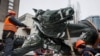 Municipal workers take down a monument to Mykola Schors, a Soviet field commander during the Russian Civil War, in Kyiv, Ukraine, Dec. 9, 2023.
