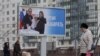 Người dân ở thành phố Saint Petersburg đi ngang qua biểu ngữ thông báo về cuộc bầu cử tổng thống sắp tới của Nga dự kiến diễn ra trong tháng này.