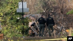 Members of the Arlington County Fire department looks towards the remains of a house explosion, in Arlington, Virginia, Dec. 5, 2023.