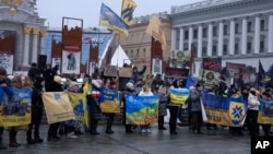 Relatives of Ukrainian soldiers captured by Russia hold posters and signs demanding that they be freed, at a flashmob in central Kyiv, Ukraine, Dec. 10, 2023.