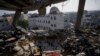 Palestinians look at a damaged residential building after an Israeli strike in Rafah, southern Gaza Strip, Jan. 10, 2024. 