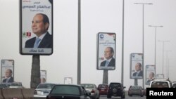 Vehicles drive past posters of presidential candidate and current Egyptian President Abdel-Fattah el-Sissi ahead of the presidential elections to be held in the country next week, in Cairo, Egypt, Dec. 5, 2023.