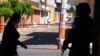 A police officer guards the area as investigators comb the site where more than a dozen people were believed to have been gunned down by armed men, in San Jose de Gracia, head of the municipality of Marcos Castellanos, in Michoacan state, Mexico, Feb. 28,