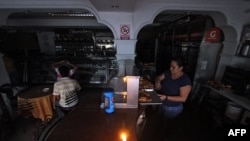 Una mujer trabaja en una panadería durante un corte de energía en el estado fronterizo de San Cristóbal, a 600 kilómetros al oeste de Caracas el 25 de abril de 2016. [AFP/Archivo]