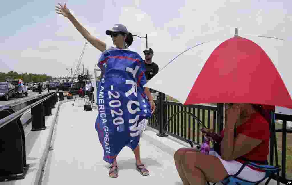 Una seguidora de Donald Trump manifiesta su apoyo desde un puente cercano a Mar-a-Lago, la propiedad registrada por el FBI el pasado lunes.