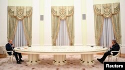 El presidente de Rusia, Vladimir Putin (izq.) recibe en su despacho en Moscú al secretario general de la ONU Antonio Guterres para acordar pasos humanitarios en favor de los civiles atrapados en el conflicto con Ucrania, el 26 de abril de 2022.