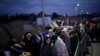 Refugjatë ukrainas duke kaluar në Poloni. 