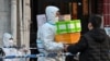 A delivery man delivers an order outside of a locked-down neighborhood after the detection of new cases of COVID-19 in Huangpu district, in Shanghai, on March 15, 2022.