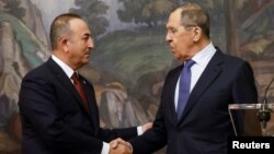Ministri i Jashtëm turk Mevlut Cavusoglu i shtrëngon dorën homologut të tij rus Sergei Lavrov në Moskë më 16 Mars. 