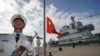 中国航母山东号停泊在海南省的一个海军基地，士兵在举行升旗仪式。（资料照：2019年12月17日）