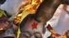 一名流亡藏人用脚睬踏被焚烧的中国总理温家宝的画像
