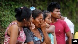 Madres angustiadas esperan en las afueras del cementerio en espera de sus seres queridos desaparecidos en Mocoa, Colombia.