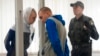 El sargento ruso Vadim Shishimarin escucha a su traductor durante una audiencia en la corte en Kiev, Ucrania, el 23 de mayo de 2022.