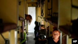 Las personas que huyen de Lysychansk y otras áreas se sientan en un tren de evacuación en la estación de tren en Pokrovsk, este de Ucrania, el 28 de mayo de 2022.