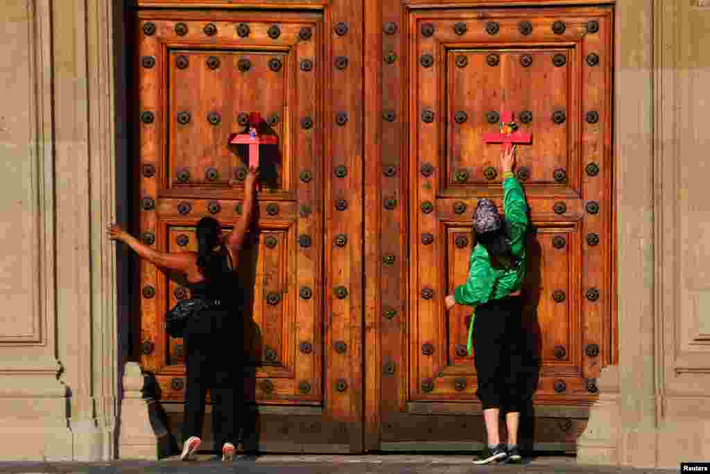 Mujeres colocan cruces en las puertas de Palacio Nacional, en la Ciudad de México, la capital del país.&nbsp;