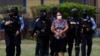 Agentes de la policía hondureña escoltan a Herlinda Bobadilla, acusada de liderar un cartel del narcotráfico, en Tegucigalpa, Honduras, 15 de mayo de 2022. Foto Reuters.