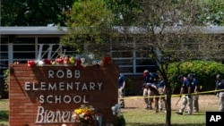 Investigadores buscan pruebas en el exterior de la escuela primaria de Robb en Uvalde, Texas, el 25 de mayo de 2022.