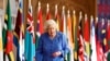 Ratu Inggris Elizabeth II berjalan melewati bendera Persemakmuran di St. George's Hall di Kastil Windsor, Inggris, untuk menandai Hari Persemakmuran pada 6 Maret 2021. (Foto: via AP)