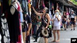 Turis asing berbelanja oleh-oleh di Bali pada Sabtu, 12 November 2022. (Foto: AP)