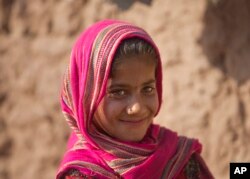 Zarmina, una niña de Afganistán, que huyó de su pueblo con su familia debido a la guerra y la hambruna, camina en un campamento de refugiados, en un suburbio de Islamabad, Pakistán, el martes 19 de junio de 2018.