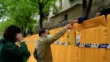 上海封城后居民从围栏上递送食用油。（2022年4月13日）