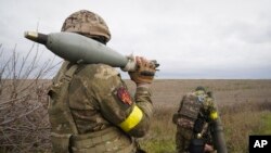 Soldados de la Guardia Nacional de Ucrania se preparan para disparar contra posiciones rusas con un mortero cerca de Kharkiv, Ucrania, el martes 25 de octubre de 2022. (Foto AP/Andrii Marienko)
