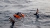 A migrant tries to board a boat of the German NGO Sea-Watch in the Mediterranean Sea, Nov. 6, 2017.