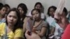 FILE - A community health worker holds up contraceptives during a lecture on family planning at a reproductive health clinic run by an NGO in Tondo city, metro Manila, January 12, 2016.