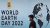 Un hombre pasa junto a un cartel, durante una campaña de limpieza de playas el día de la Tierra, en Mumbai, India, el 22 de abril de 2022.