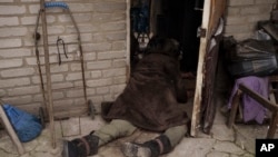 Un perro junto al cuerpo de una anciana asesinada en la entrada de su casa en Bucha, en las afueras de Kiev, Ucrania, el martes 5 de abril de 2022.