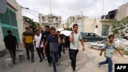 巴勒斯坦人在加沙拉法城的西北地区将一名在以军攻击中死亡的人下葬。(6月22日)