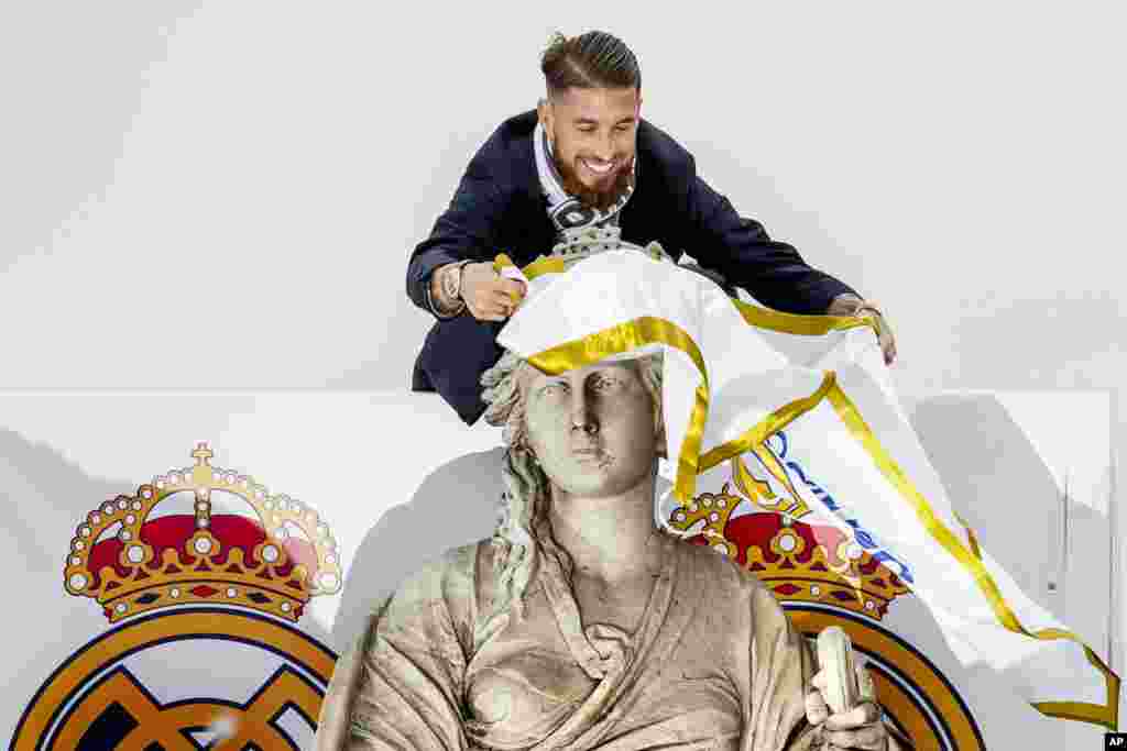 Pemain Real Madrid Sergio Ramos mengalungkan bendera Real madrid ke patung Dewi Cibeles di lapangan monumen Cibeles setelah Real Madrid menjuarai Liga Champions di Madrid, Spanyol.