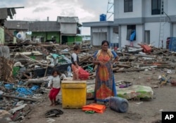 Las personas buscan en los escombros cerca de los sitios donde estaban sus casas antes del devastador tsunami en Indonesia.