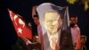 Men, holding a banner with a picture of Turkey's President Recep Tayyip Erdogan, celebrate outside his Justice and Development Party, or AKP, headquarters in Istanbul, June 24, 2018.