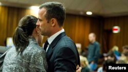 Oscar Pistorius habla con su hermana Aimee durante el quinto día del juicio por el asesinato de su novia.
