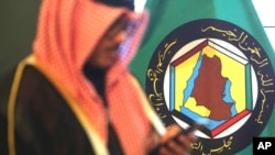 Foto tomada el 5 de diciembre del 2017 de un hombre frente al estandarte del Consejo de Cooperación del Golfo en Kuwait. 