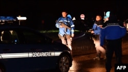 Gendarmes stand guard on a road near a retirement home for monks in Montferrier-sur-Lez, southern France, early on Nov. 25, 2016, after an armed man burst into the home, killing a woman.