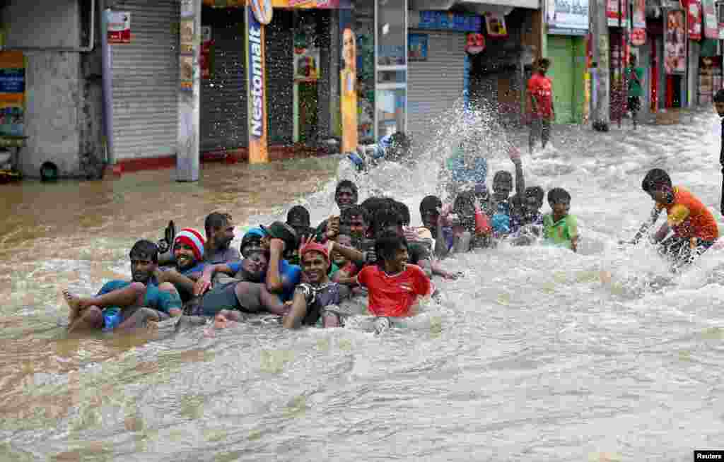 Warga di kota Biyagama, Sri Lanka bermain di jalanan yang tergenang air, setelah rumah mereka terendam banjir.