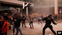 Policías antidisturbios se enfrentan con manifestantes afuera del aeropuerto El Prat de Barcelona, España, el 14 de octubre de 2019.