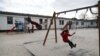 FILE - Children play in a playground at the camp for migrants and refugees in Friedland, Germany, April 4, 2016.