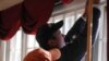 Work crews replace windows with double-pane glass as part of one family's effort to reduce its carbon footprint.