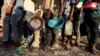 FILE - Ethiopian refugees who fled the country's restive Tigray region queue to receive food aid at the Um-Rakoba camp in Al-Qadarif state, in Sudan, Dec. 11, 2020.