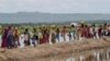Muslim Rohingya, yang menghabiskan empat hari di tempat terbuka setelah menyeberang dari Myanmar ke Bangladesh, membawa barang-barang mereka setelah diizinkan menuju kamp pengungsian di Palong Khali, Bangladesh, 19 Oktober 2017. (Foto: AP)