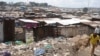 FILE - A man walks by the slum of Mathare in Nairobi, May 28, 2014. 
