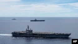 ARCHIVO - En una fotografía proporcionada por la Armada de EEUU, buques de guerra estadounidenses navegan juntos en formación, en el Mar de China Meridional, el 6 de julio de 2020.