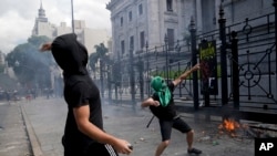 Manifestantes lanzan piedras durante una protesta frente al Congreso mientras los legisladores se preparan para votar una ley para ratificar el acuerdo del gobierno con el Fondo Monetario Internacional, en Buenos Aires, Argentina, el jueves 10 de marzo de 2022.